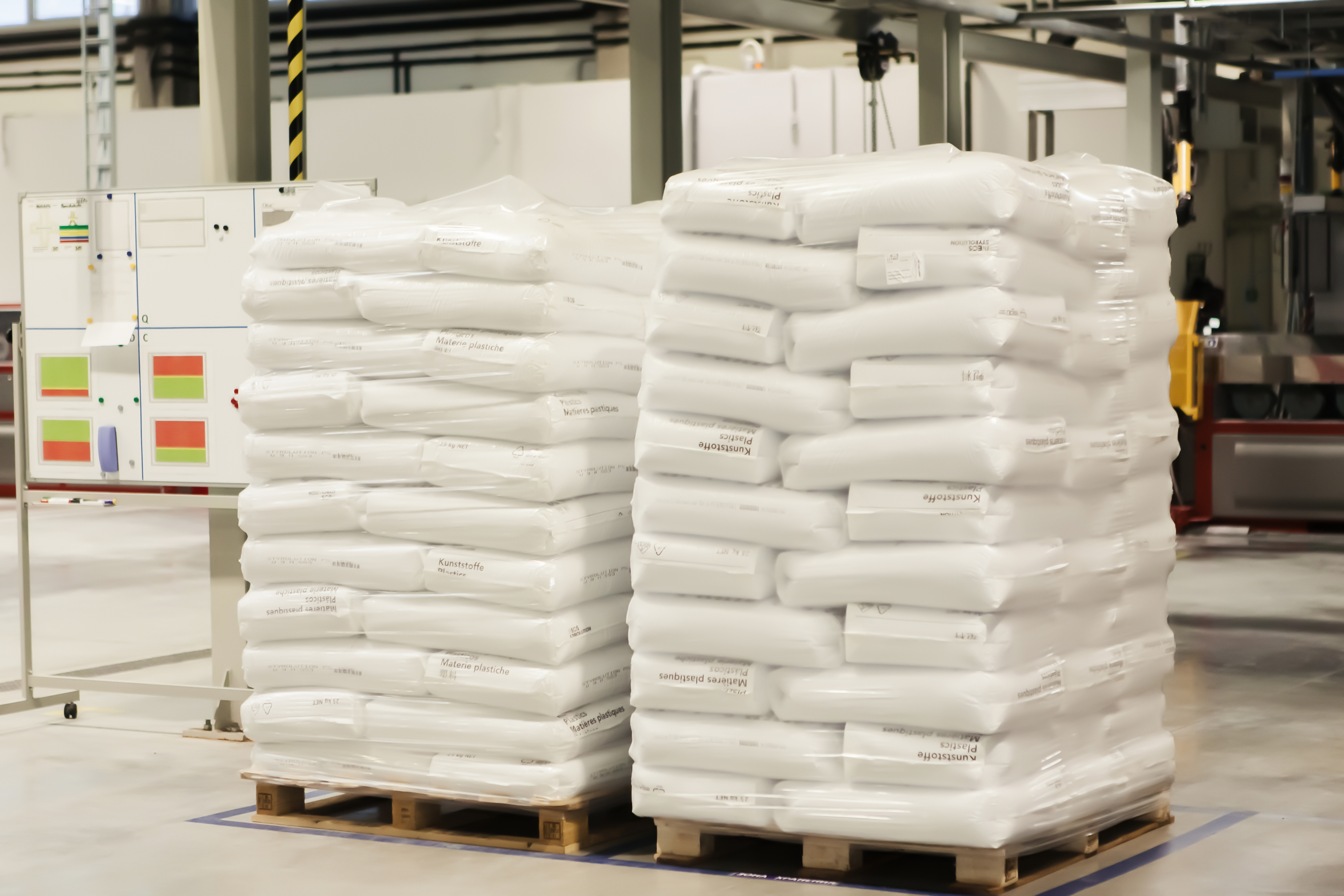 Polythene valve sacks stacked on top of each other on wooden pallets in a warehouse demonstrating the benefits of streamlined packaging and space saving solutions.  