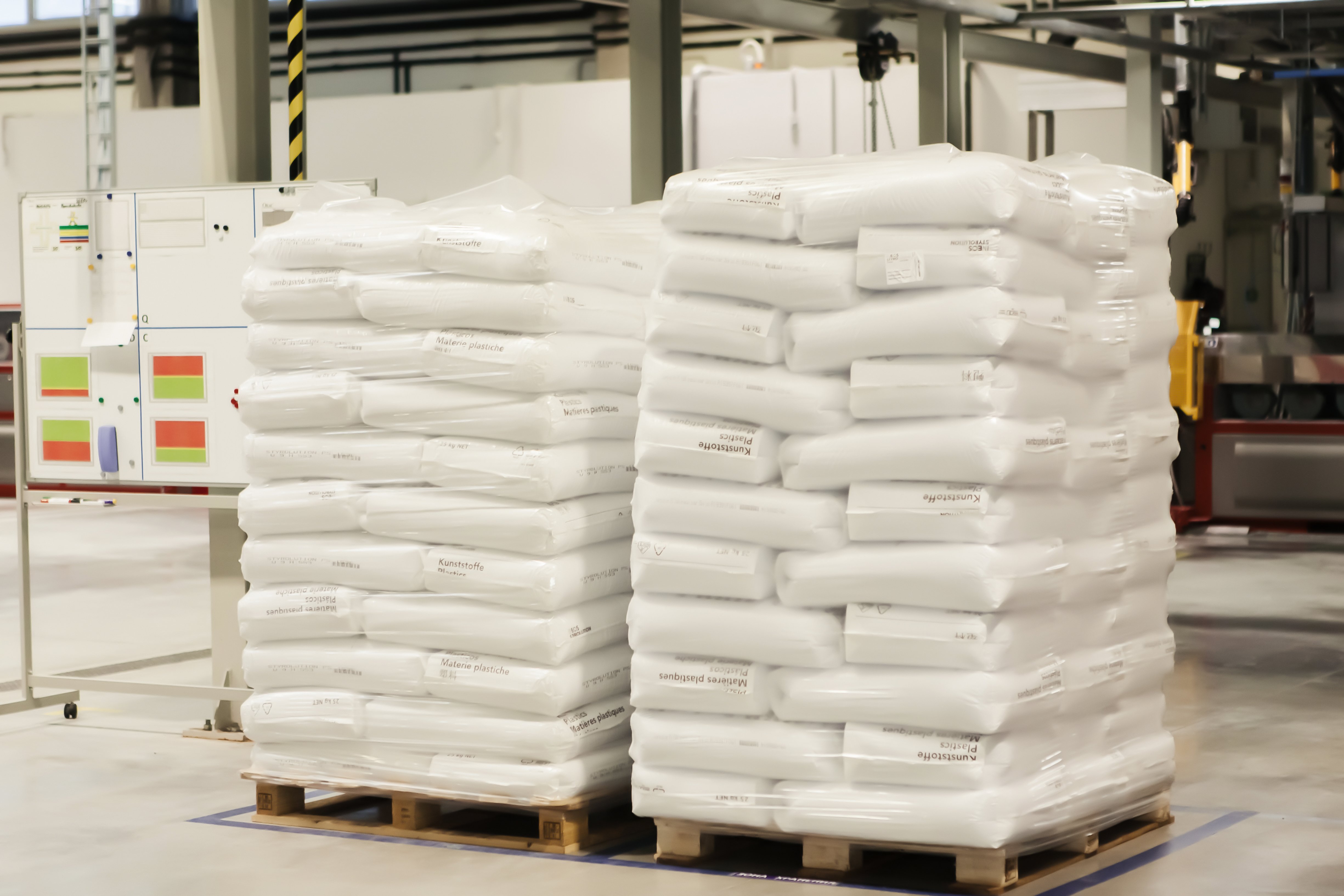 Polythene valve sacks stacked on top of each other on wooden pallets in a warehouse demonstrating the benefits of streamlined packaging and space saving solutions. 